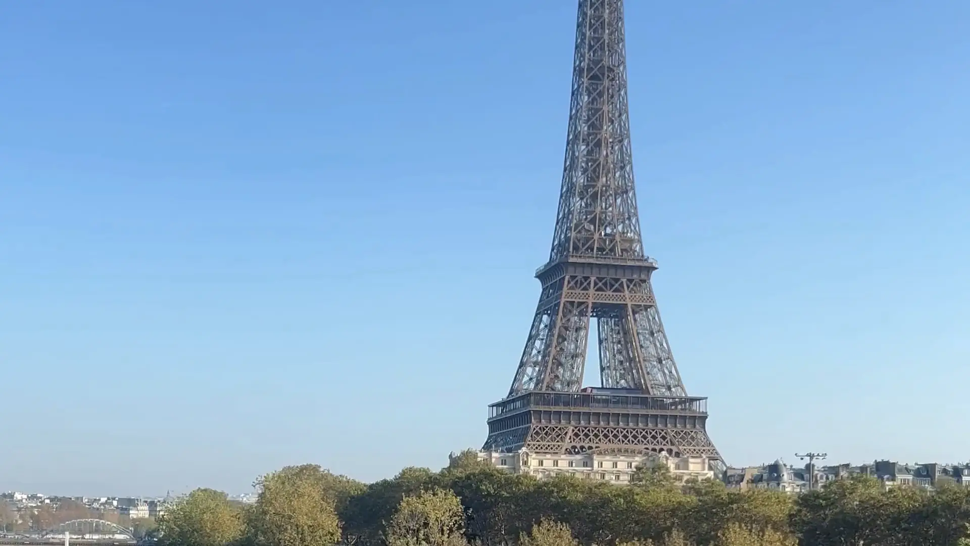 La tour Eiffel au-dessus des arbres, sous un ciel clair